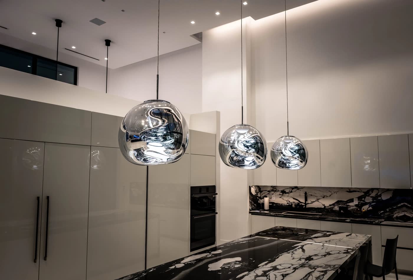 Pendants over a kitchen island, lit at night